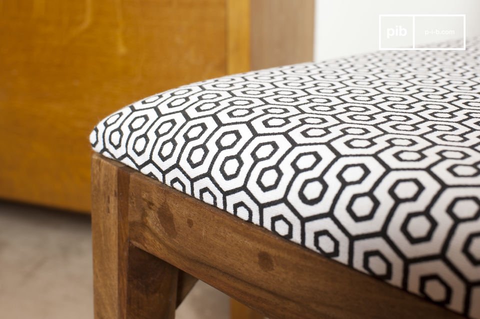 De stoel heeft hoekige lijnen die de retro patronen van het textiel van de zitting benadrukken