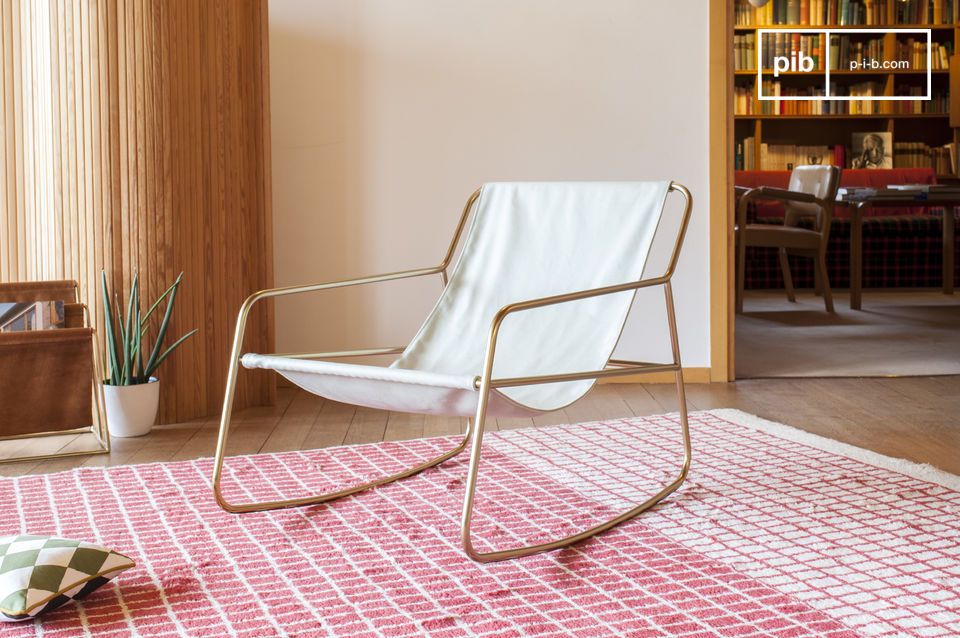 Elegante schommelstoel van wit canvas met een gouden structuur.#
