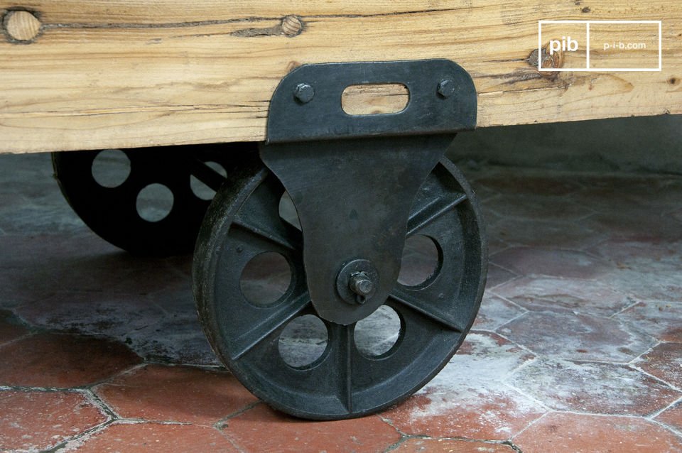 de tafel is gemaakt van dik gelakt hout en gemonteerd op gietijzeren wielen.